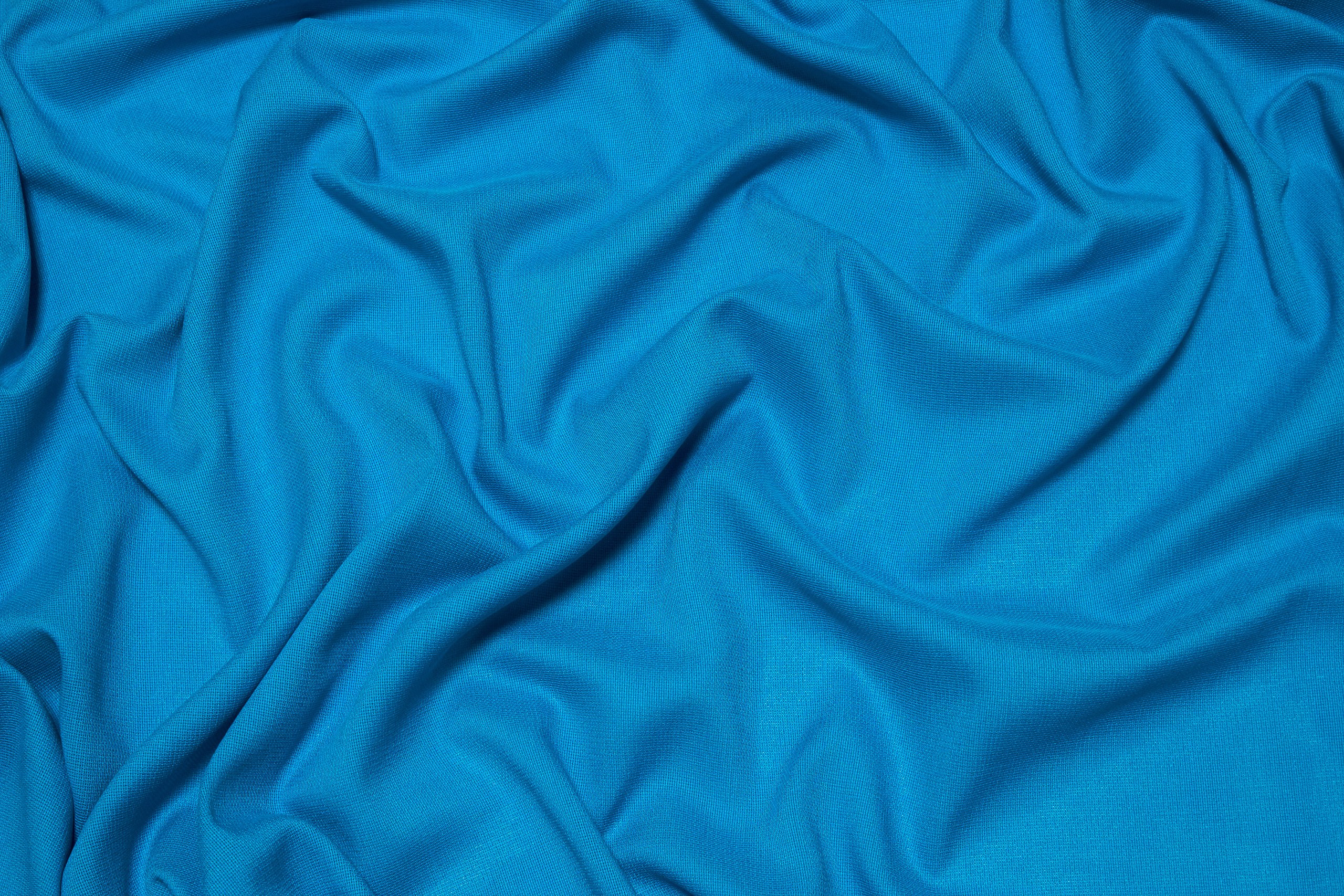 Однотонная ткань. Канва голубая с разводами. Ткань вискоза голубая с облаками. Атласная вискоза синего цвета с узором.